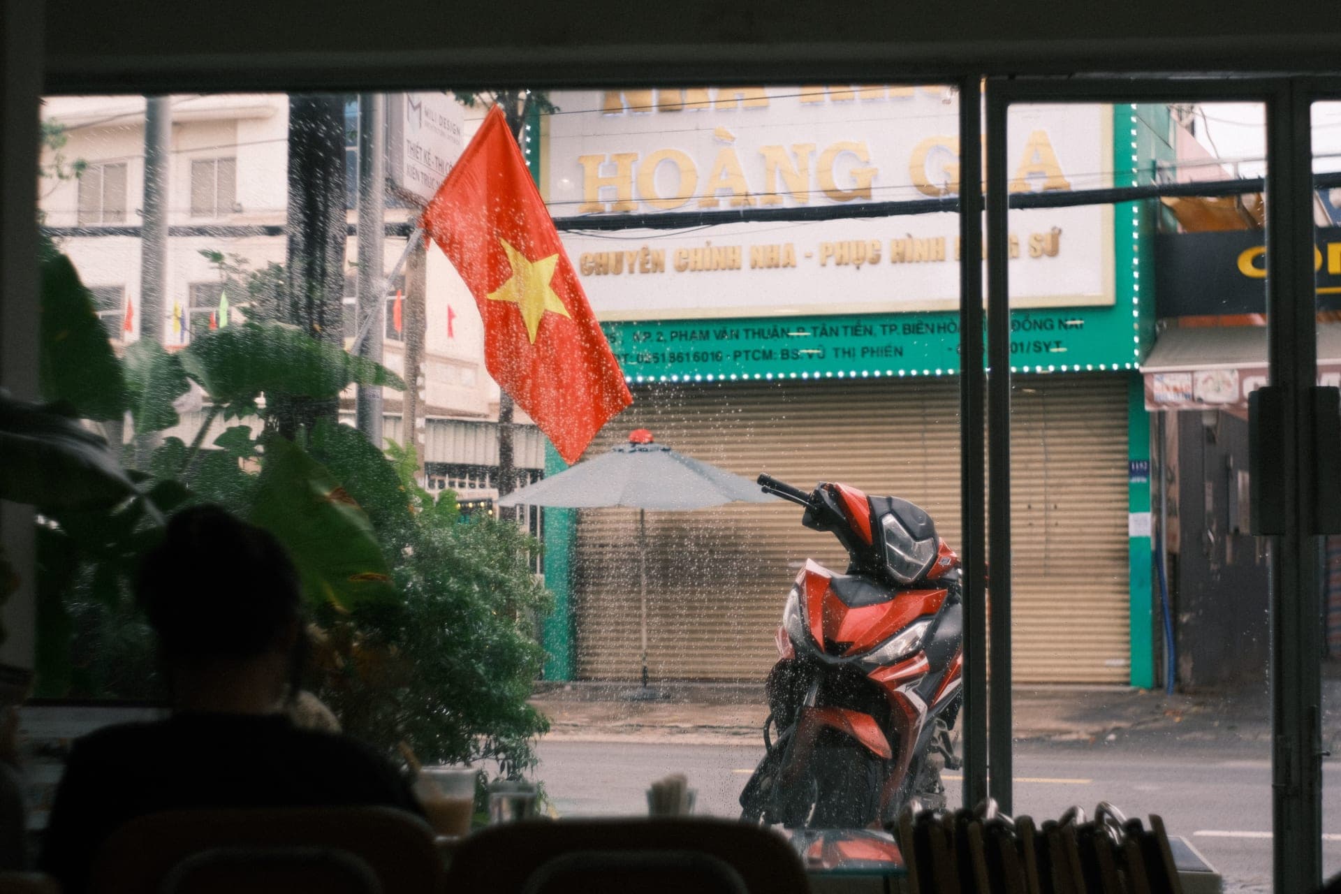 Rainy Vietnamese street seen from a cafe window